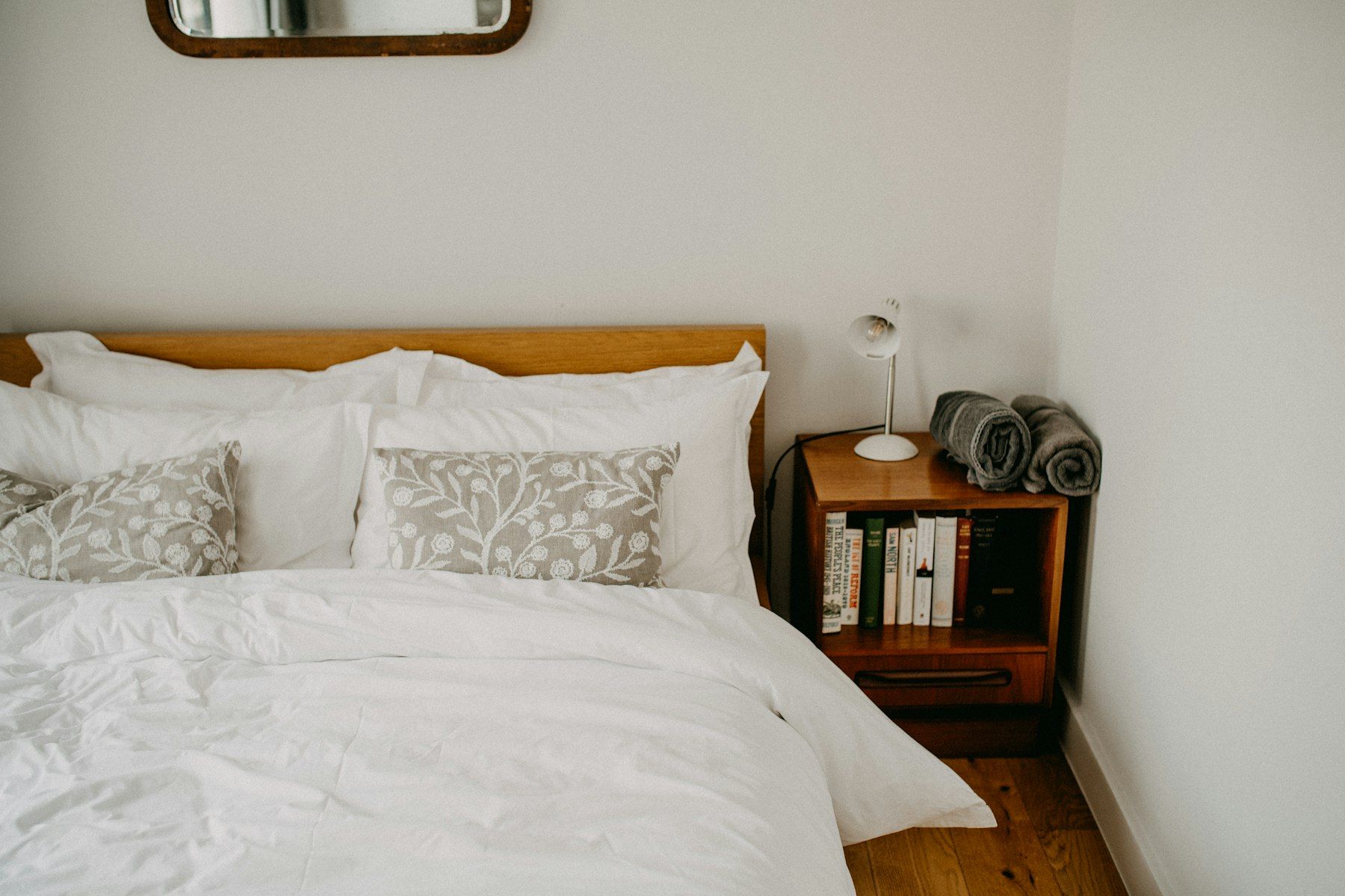 A neatly made guest bed with a bedside lamp