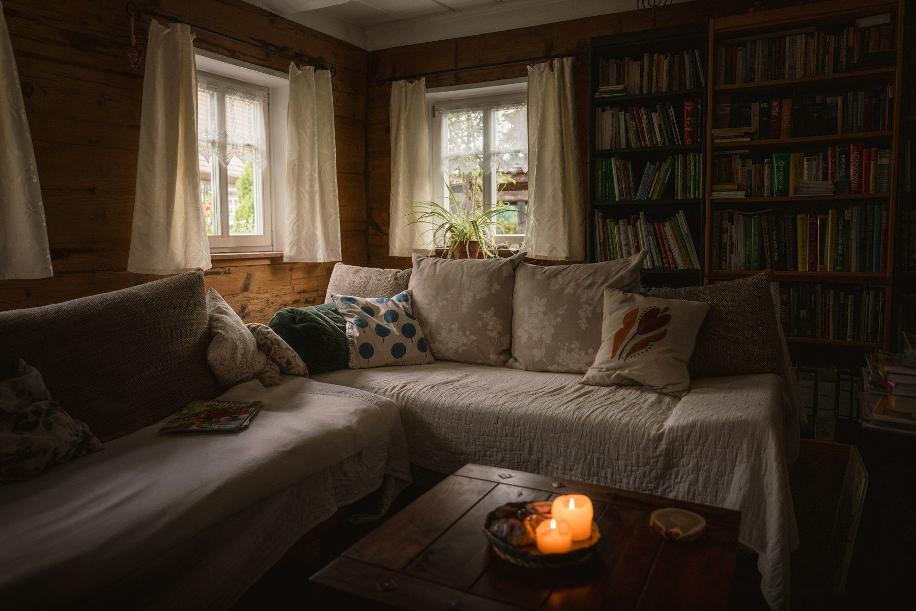 A cosy sitting room with candles lit on the coffee table