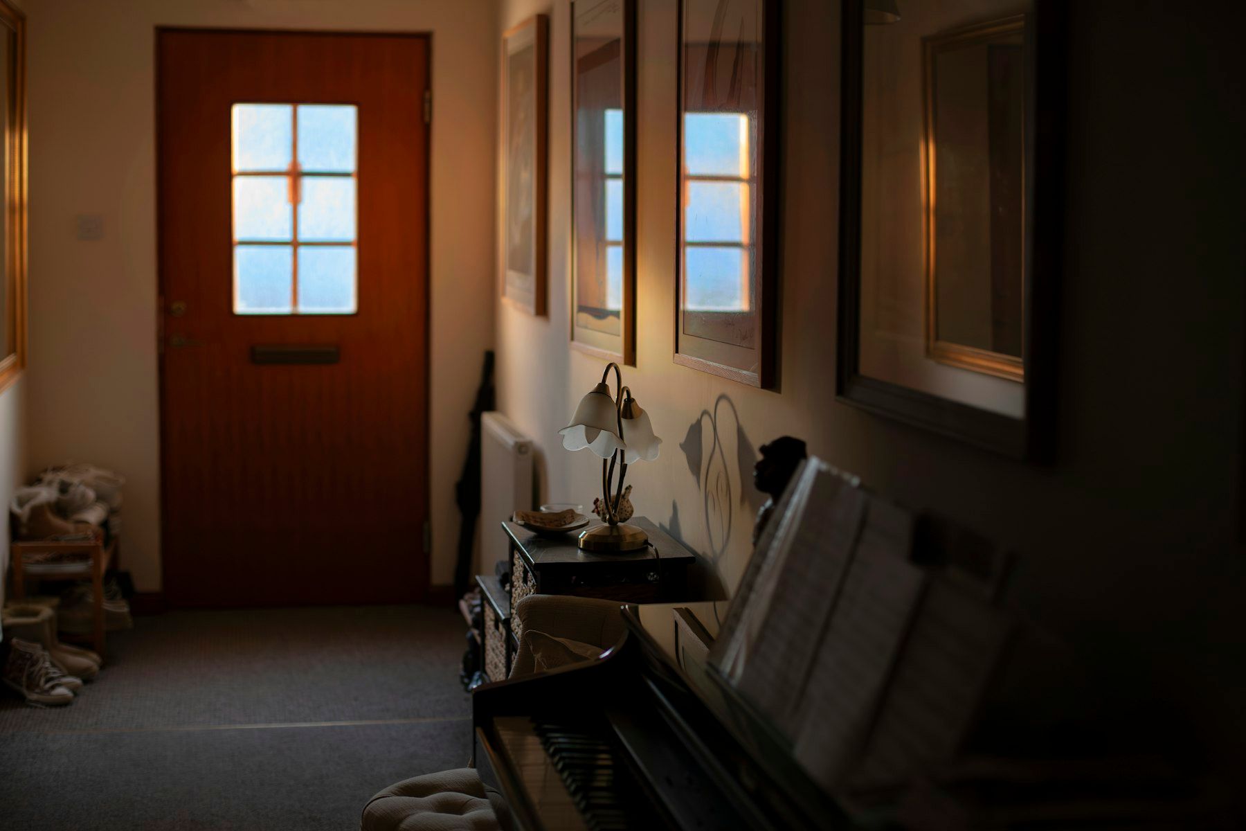 A warm-lit cottage hallway with a wooden front door